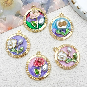 Detailed macro view of vintage enamel flower pendants with gold alloy frame and pearl accents