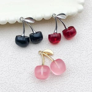 Close-up of resin cherry charms in black, red and pink for DIY jewelry making crafts
