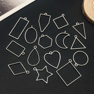 Macro view of silver geometric DIY jewelry frames including heart star and moon shapes