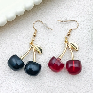 Realistic resin cherry earrings with red and black fruits and gold leaf hooks on white texture