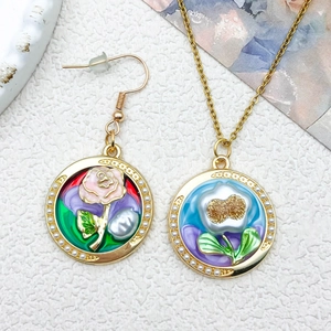 Detailed close-up of retro floral enamel necklace and earring set with bead border