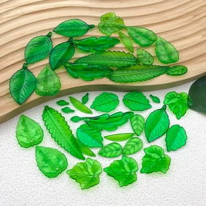 Vue détaillée de breloques feuilles en acrylique vert translucide pour bijoux DIY