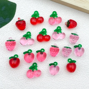 Detailed view of DIY resin fruit pendants including red cherry and pink strawberry charms