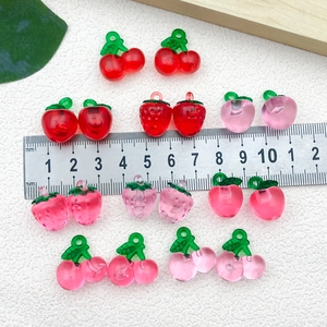 Macro detail of DIY resin fruit pendants like strawberries and cherries for jewelry making