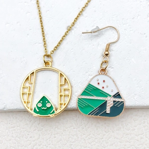 Detail van goudkleurige legering ketting en oorbellen set met groene Zongzi emaille hangers