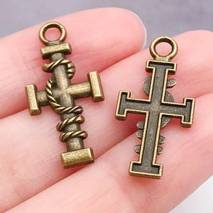 Detalle macro de colgantes de cruz en bronce antiguo con textura de cuerda y parte trasera