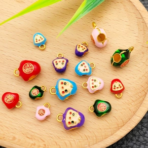 Détails de breloques zongzi en émail coloré sur plateau en bois pour bijoux artisanaux