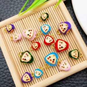 Pendentifs colorés à visage souriant en plusieurs tailles et couleurs sur un plateau