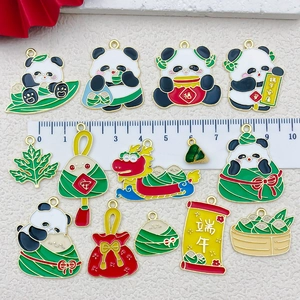 Detail of enamel Dragon Boat Festival charms showing panda and zongzi with ruler scale