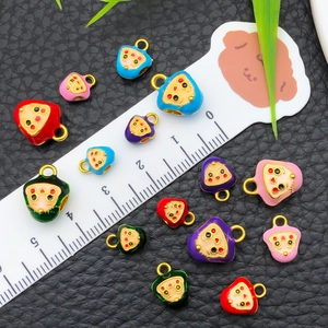 Pendentifs colorés en émail en forme de boulette de riz sur fond noir texturé
