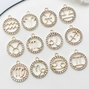 Détail de pendentifs signes du zodiaque dorés avec strass brillants pour bijoux DIY