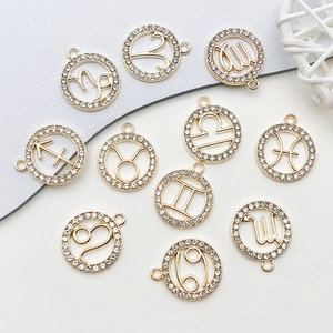 Gros plan de pendentifs zodiaque dorés avec strass pour création de bijoux artisanaux
