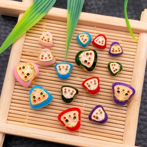 Macro detail of colorful Daruma enamel beads with drip oil finish on bamboo tray