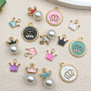 Détail macro de pendentifs couronnes en émail coloré avec perles et strass pour bijoux DIY