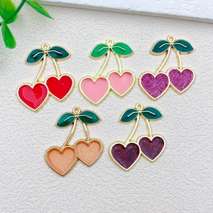 Detail of five colorful cherry fruit charms with heart-shaped fruits and green leaves