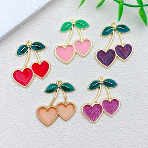 Detail of heart-shaped cherry alloy charms with colorful enamel for DIY jewelry making