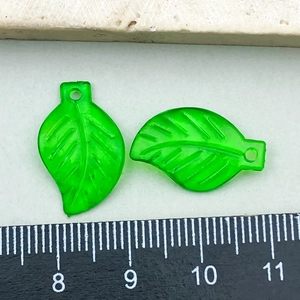 Macro detail of green acrylic leaf charms showing vein texture and size measurement