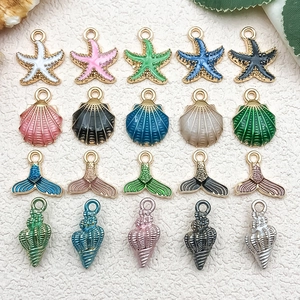 Vue détaillée de breloques en émail coloré en forme de coquillage et étoile de mer pour bijoux