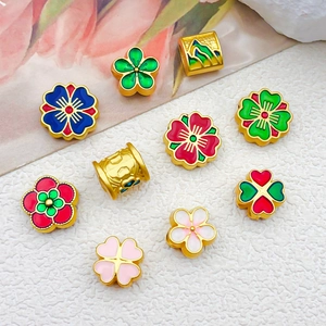 Vue détaillée de perles florales en émail et breloques dorées pour bijoux DIY