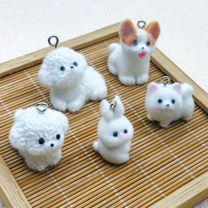 Detail of five handmade flocked resin dog charms on a bamboo tray for DIY crafts