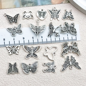 Antique silver butterfly charms set with hollow designs and measurement ruler display