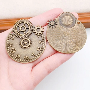 Vista dettagliata dei ciondoli a ingranaggi steampunk in bronzo per mostrare scala e trama