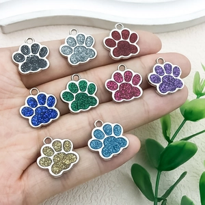 Primer plano de nueve colgantes de huellas brillantes de colores para joyas DIY y llaveros