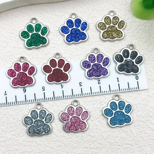 Vista de 10 colgantes de huella de perro con purpurina de colores, escala y anillos