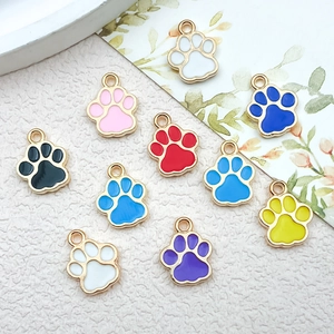 Macro view of colorful enamel cat paw charms with gold metal frames for DIY jewelry