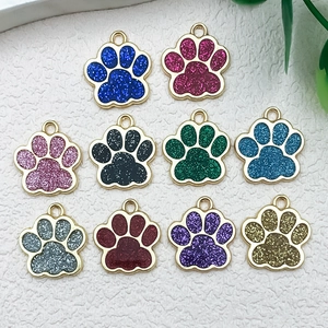 Detailed macro shot of ten colorful glitter paw print charms for DIY jewelry making