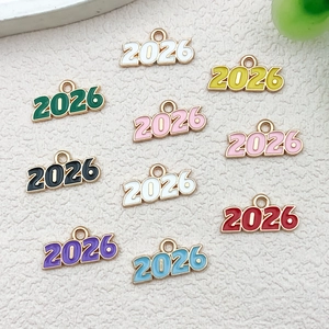 Détail macro de pendentifs année 2026 en émail coloré pour la création de bijoux DIY