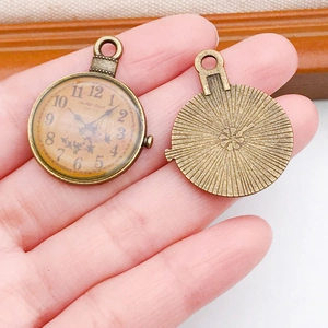 Dettagli di ciondoli orologio in bronzo vintage con numeri romani e rilievo floreale