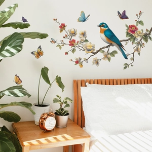 Wall decals featuring birds and flowers in a cozy bedroom with natural window shadows