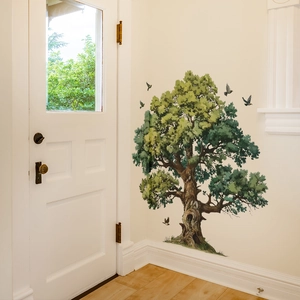 Detailed view of hand-painted green tree and flying birds wall decals on a white room corner