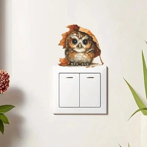 Cute cartoon owl wall sticker above a light switch with autumn leaves and home decor details