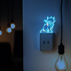 Luminous cat-shaped LED night light with blue galaxy pattern on a wall socket