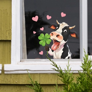 Cartoon cow window sticker with green clover and pink hearts on glass surface