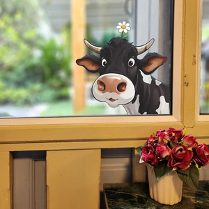 Cartoon cow wall sticker with white flower decoration on a bright window glass