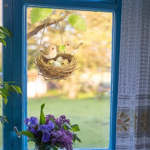 Cartoon wall decal featuring yellow birds in a nest with eggs hanging on a tree branch