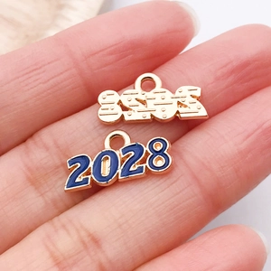 Vue macro du pendentif chiffre 2028 doré avec émail bleu sur la paume pour référence