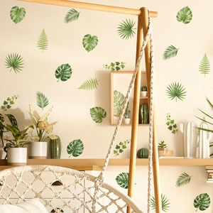 Tropical green monstera and palm leaf wall stickers in a cozy home living room