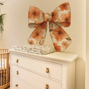 Self-adhesive wall sticker featuring large orange floral bow design for bedroom decor