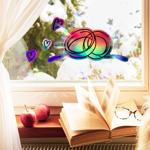 Rainbow prism heart window sticker reflecting vibrant colors on a snowy windowsill