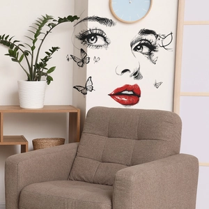 Artistic wall decal showing a female face with red lips and butterflies in a modern room
