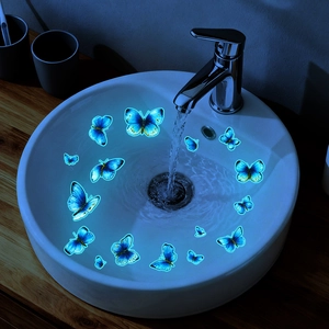 Luminous blue butterfly wall stickers glowing in a bathroom sink for home decoration