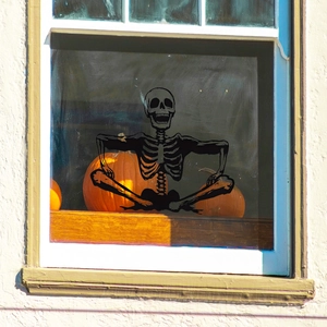 Smiling skeleton silhouette wall sticker for Halloween window decor with pumpkins