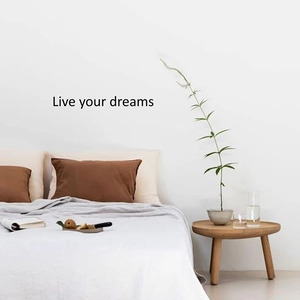 Minimalist 'Live Your Dreams' wall decal sticker above cozy bedroom bed with Nordic decor