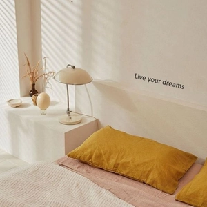Detail of inspirational 'Live your dreams' wall sticker in a minimalist Nordic bedroom