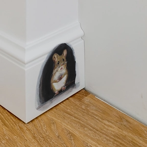 Cute hand-drawn mouse hole wall sticker on white baseboard with light wood floor