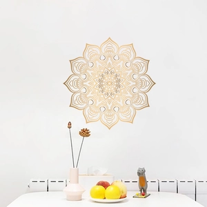 Detail view of golden mandala wall sticker with geometric patterns on a white wall